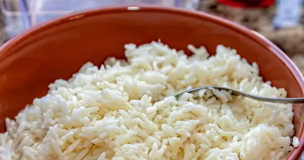 Panela com arroz branco soltinho sendo preparado na cozinha