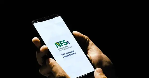 Profissional emitindo nota fiscal digital em um computador, representando a nova regra do Emissor Nacional no DF.